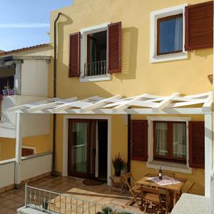 une maison avec une pergola blanche sur une terrasse dans l'établissement Santa Teresa Gallura Green House, à Santa Teresa Gallura