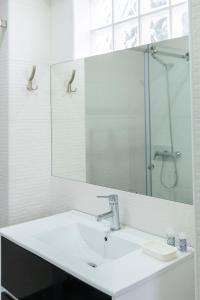 uma casa de banho branca com um lavatório e um espelho em Casa dos Terraços Apartamentos em São Martinho do Porto
