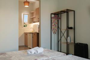 a room with a bed with two white towels on it at Feeloxenia Corfu Apartments in Acharavi