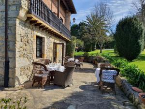 un patio con mesa y sillas frente a un edificio en Posada San Tirso, en Toñanes