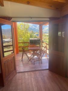 a porch with a table and a view of the mountains at Cabaña El Churqui in Tafí del Valle