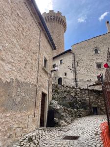 uma rua de calçada em frente a um castelo em Terra della Baronia em Santo Stefano di Sessanio