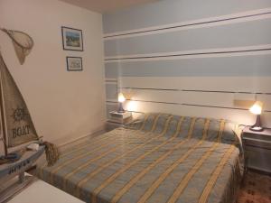 a small bedroom with a bed and two lamps at Verahouse in Viareggio