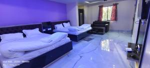德奧加爾的住宿－Vaidehi Inn-A Unit of vaidehi guest house，一间卧室配有两张床和一张沙发。