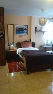 a bedroom with a bed and a table and a mirror at Hospedaje Boutique LEOS EIRL in Lima