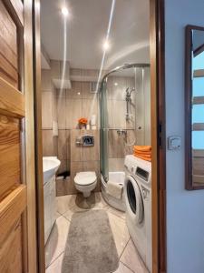 アウグストゥフにあるAugustów Apartament Aramisのバスルーム(トイレ、洗濯機付)