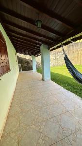 eine Veranda mit einer Hängematte, die von einem Gebäude hängt in der Unterkunft Casa Ipê in Monte Verde