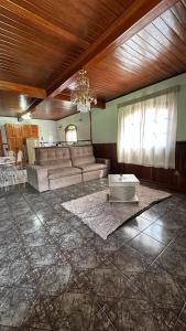 un soggiorno con divano e tavolo di Casa Ipê a Monte Verde