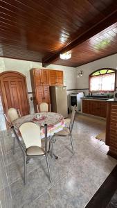 a kitchen with a table and chairs and a refrigerator at Casa Ipê in Monte Verde