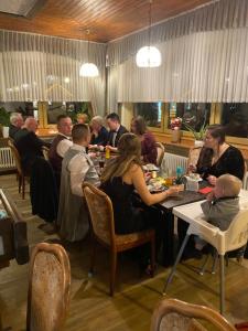 a group of people sitting at a table in a restaurant at Hotel-Restaurant Theis-Muehle in Biersdorf am See