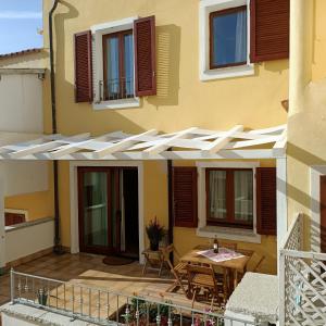 une maison avec un patio et un toit blanc dans l'établissement Santa Teresa Gallura Green House, à Santa Teresa Gallura