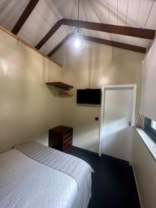 um quarto com uma cama e uma televisão na parede em Quiet Place em Machico