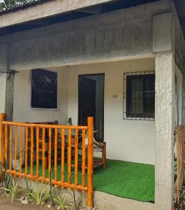 a house with a porch and green grass at Jea's Room Rental in Balatero