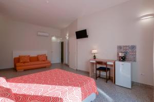 曼杜里亞的住宿－Le tre zie B&B，一间卧室配有一张床、一张桌子和一张沙发