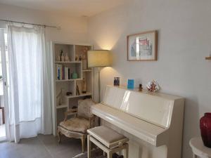 a living room with a white piano and a chair at Maison 4/6 pers avec piscine proche des plages in Sausset-les-Pins