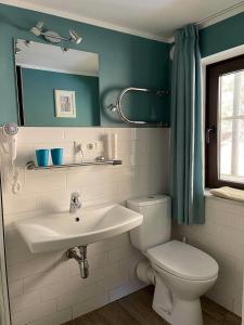 ein Badezimmer mit einem Waschbecken, einem WC und einem Spiegel in der Unterkunft Bergbach in Ramsau bei Berchtesgaden