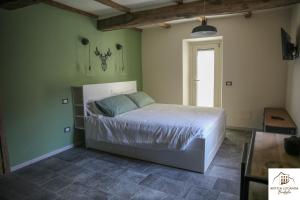 a bedroom with a bed in a green wall at Antica Locanda Bonfiglio in Busana
