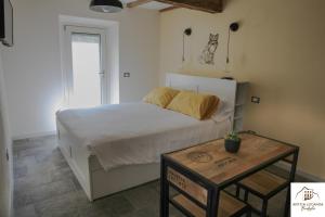 a bedroom with a bed and a table at Antica Locanda Bonfiglio in Busana