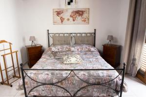 1 dormitorio con 1 cama con colcha de flores en Colombohouse87, en Quartu SantʼElena