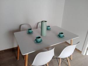 a white table with cups on it with chairs at Apartamento Peonía in Jerez de la Frontera
