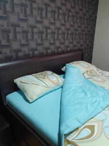 a bed with two pillows on top of it at Apartman KGC Stara Pazova in Stara Pazova