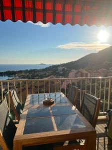 einen Holztisch auf einem Balkon mit Meerblick in der Unterkunft Super appartement vue Sanguinaires in Ajaccio