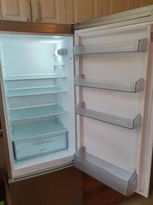 an empty refrigerator with its door open in a kitchen at Apartman KGC Stara Pazova in Stara Pazova