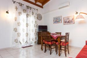 a dining room with a table and chairs and a television at Colombohouse87 in Quartu SantʼElena