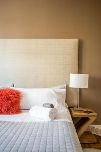 Un dormitorio con una cama blanca con una almohada roja y una lámpara en Gabby's Place Downtown Core, en Toronto