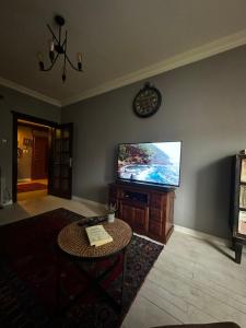 a living room with a flat screen tv and a table at İsra Suit in Trabzon