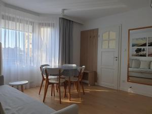 a room with a table and chairs and a bedroom at Messina Apartamenty Wyspa Sobieszewska in Gdańsk