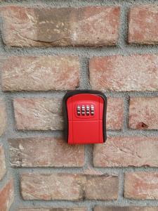 a red object on a brick wall at Fewo Jax in Boos