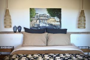 ヴナスクにあるMas Saint-Geniesの壁に絵が飾られたベッドのある寝室