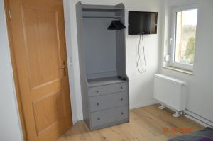 um quarto com uma cómoda, uma televisão e uma porta em Ferienwohnung Fillsack 