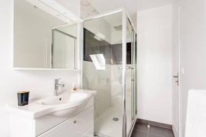 a white bathroom with a sink and a shower at Appartement cosy proche Paris Orly - Climatisé in Morangis +17 photos