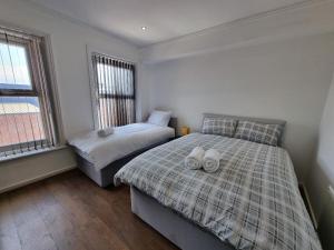 a bedroom with two beds with towels on them at PL Liverpool in Liverpool