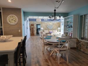 comedor y sala de estar con mesa y reloj en WaterFront Mid Century Cottage - Close to beach - 2 BR 3 BA en Ruskin