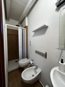 a white bathroom with a toilet and a sink at Borgo degli Svevi rooms in Bari