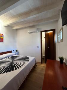 a bedroom with a large bed and a wooden table at Borgo degli Svevi rooms in Bari