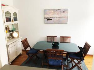 a dining room table with chairs and a painting on the wall at Bonito chalet a 2 Km de Liencres y playas. in Mortera