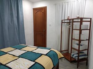 a bedroom with a bed and a wooden shelf at Mini departamento en Quito 1 in Quito