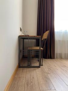 a table and chair in a room with a window at Sargsyan ECO house in Sevan