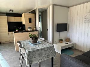 salon ze stołem i kuchnią w obiekcie Cottage parc résidentiel de loisir w mieście Saubrigues
