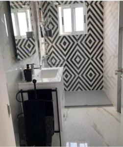 W łazience znajduje się umywalka i lustro. w obiekcie Modern penthouse with sea view w mieście Punta Prima