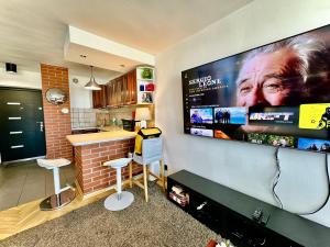 a kitchen with a large tv on a wall at Super Apartament WHITE Warszawa 2x Metro Ścisłe Centrum WiFi 300 Mbs NEW in Warsaw