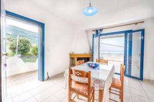 a dining room with a table and a view of the ocean at Amazing View in Akhladherí