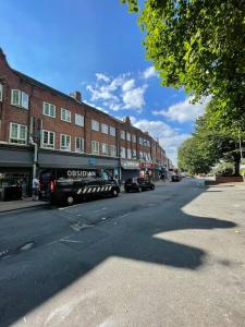 une camionnette noire garée sur le côté d'une rue de la ville dans l'établissement Immaculate 1 bedroom apartment in Orpington, à Orpington