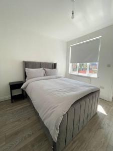 un grande letto in una camera da letto con finestra di Immaculate 1 bedroom apartment in Orpington a Orpington