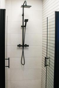 ducha con cabezal de ducha en la pared en Apartament White-Niska z garażem podziemnym, en Kielce