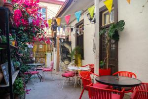 un patio con mesas, sillas rojas y flores en Casa Volante Hostal, en Valparaíso
